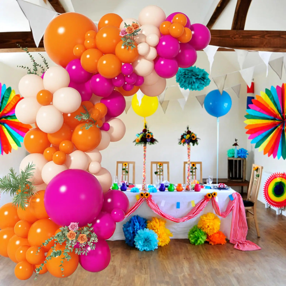 A vibrant balloon garland arch featuring pink, orange, and purple balloons decorating a party setup.