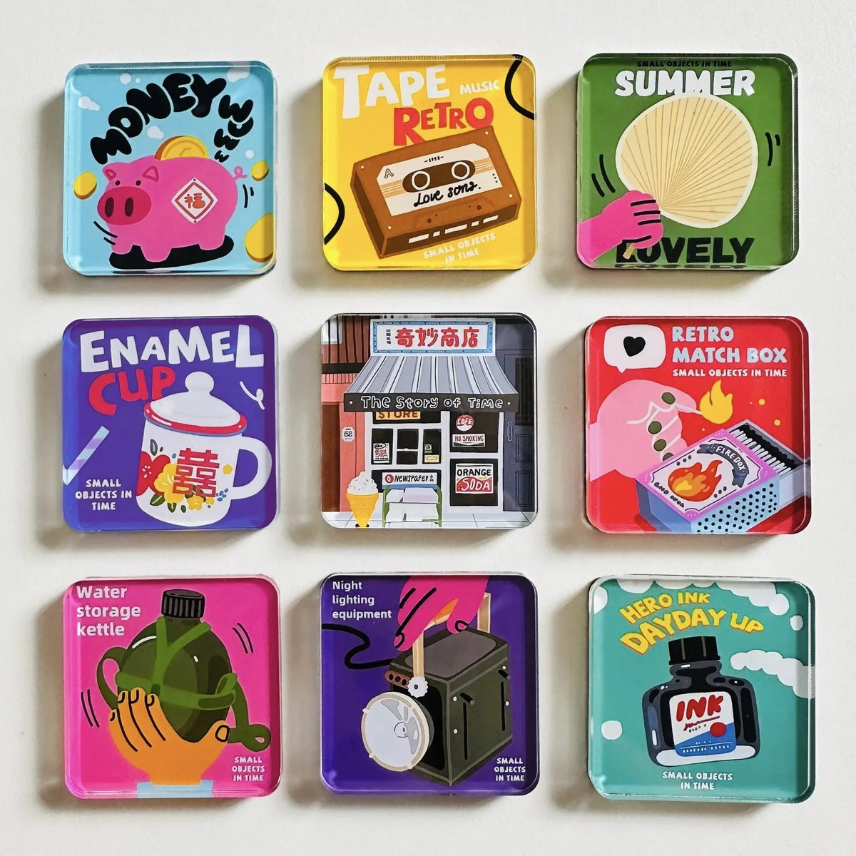 A collection of colorful acrylic fridge magnets featuring various themes like money, tape, summer, enamel cups, and ink bottl