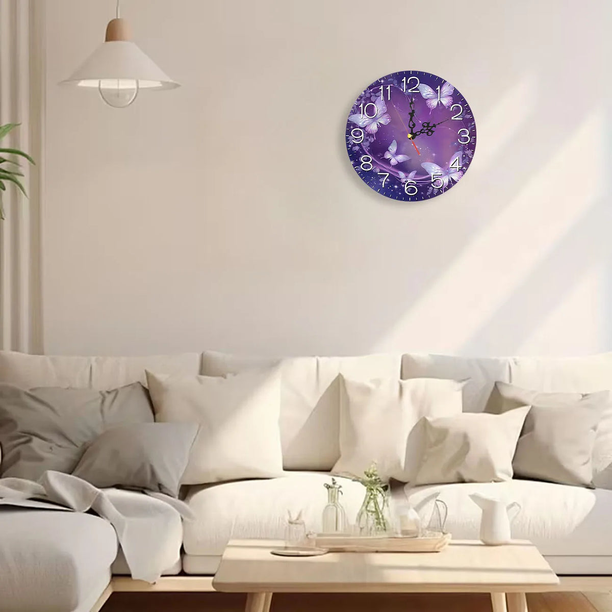 A modern round purple and silver wall clock hangs on a white wall above a light-colored sofa.