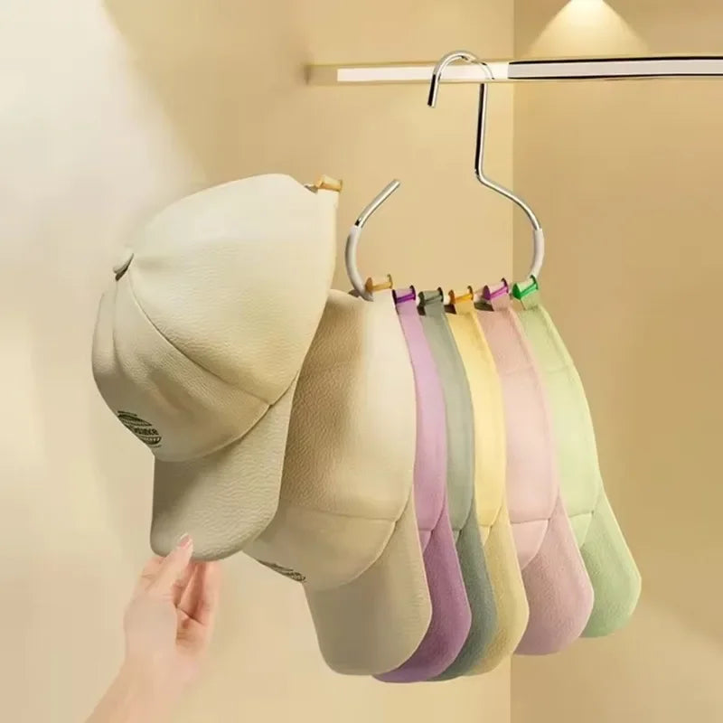 A display of various colored circle hats hanging from a metal hanger against a light wall.