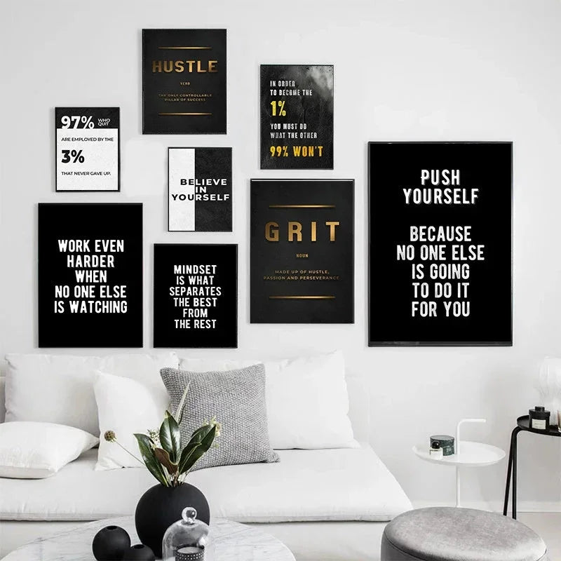 A gallery wall featuring various motivational quotes on black canvas prints displayed above a white sofa.