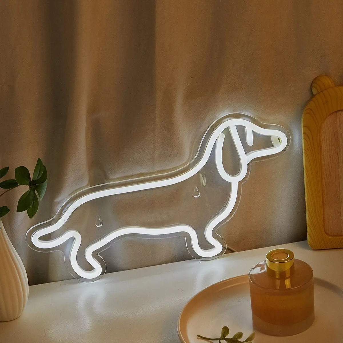 A glowing white neon sign shaped like a dog silhouette is displayed on a table.