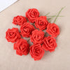 A cluster of twenty vibrant red foam rose blooms arranged on a beige fabric background.