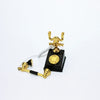 A vintage rotary desk phone miniature decor with gold accents and a black base.