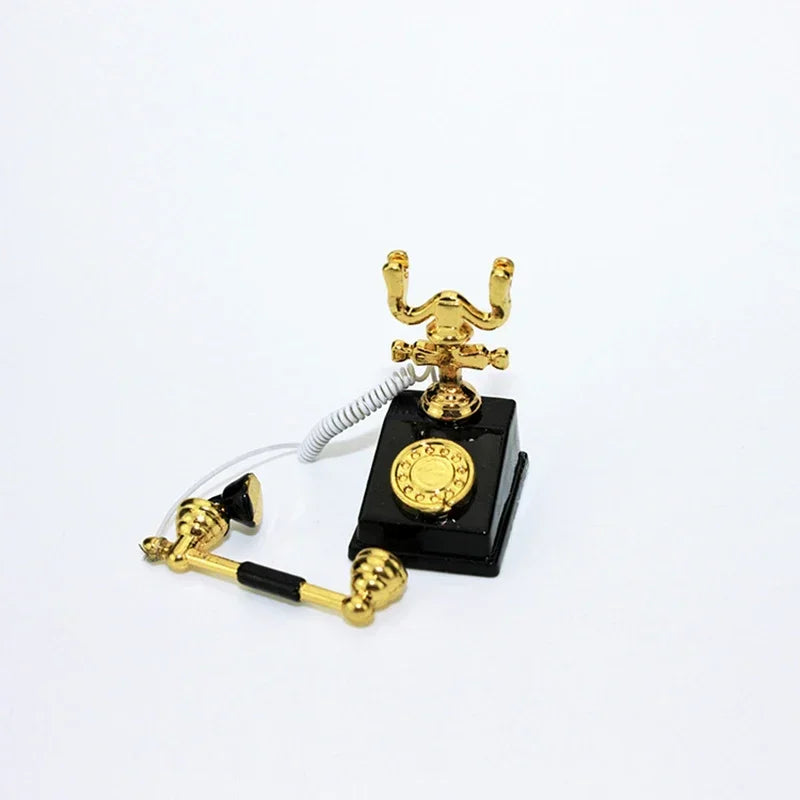 A vintage rotary desk phone miniature decor with gold accents and a black base.