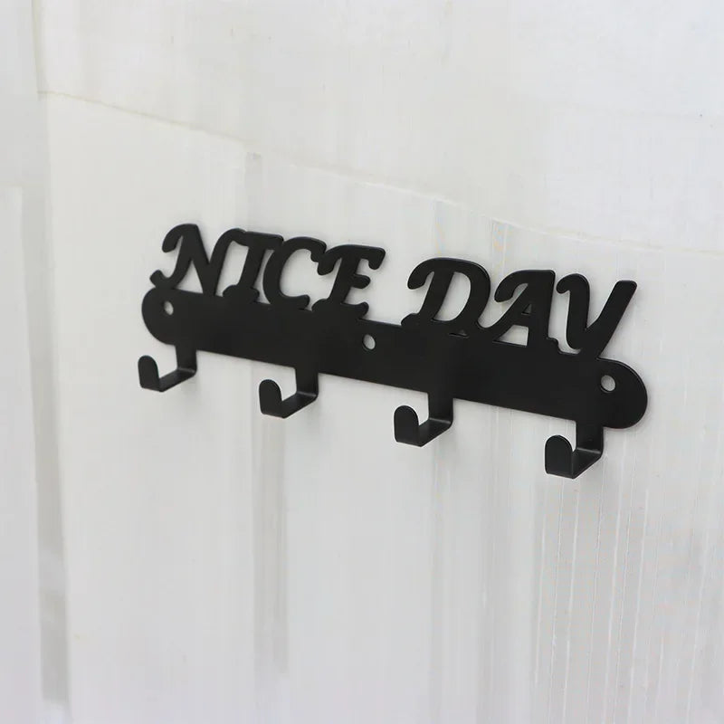 Black metal wall-mounted sign spelling out NICE DAY with seven hooks.