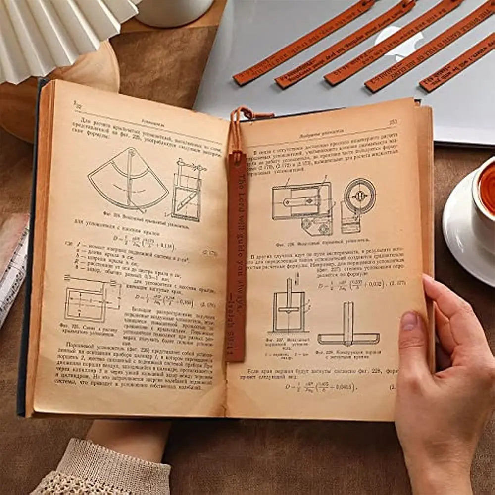 An open leather book showing pages with text and diagrams, next to a ruler.