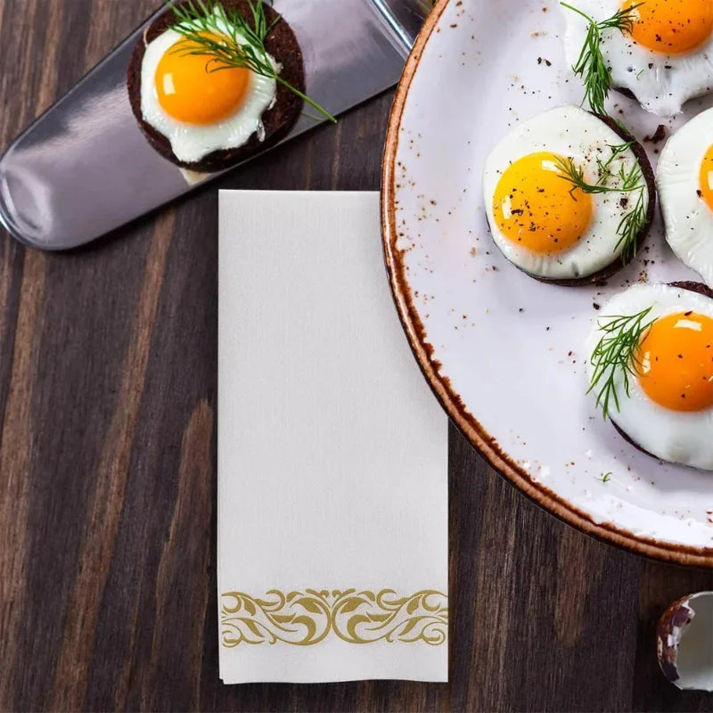 A plate of fluffy fried eggs with rose gold trim and a side of dark toast on a wooden surface.