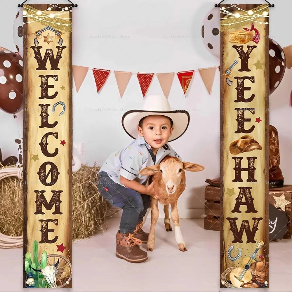 A young boy dressed in western attire sits with a lamb in front of a wooden banner decorated with the words WELCOME YEAH HAW