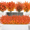 Two artificial fall eucalyptus and flower stems in vibrant orange and red hues displayed in outdoor planters.