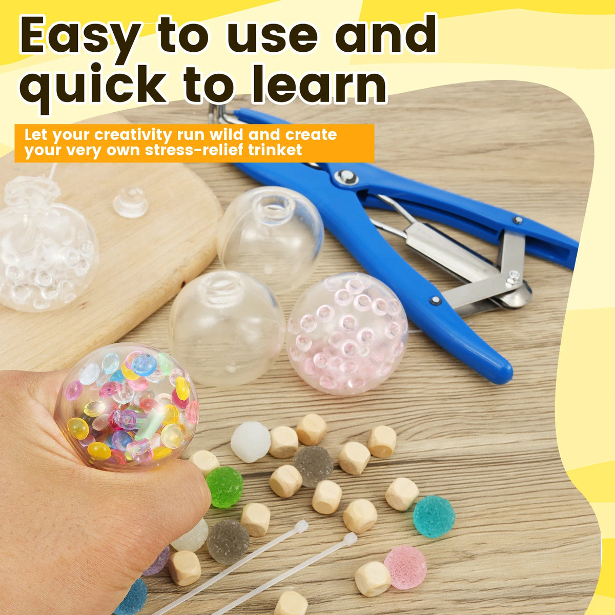 A hand holds a colorful stress ball, surrounded by various beads and crafting tools for making DIY stress relief trinkets.