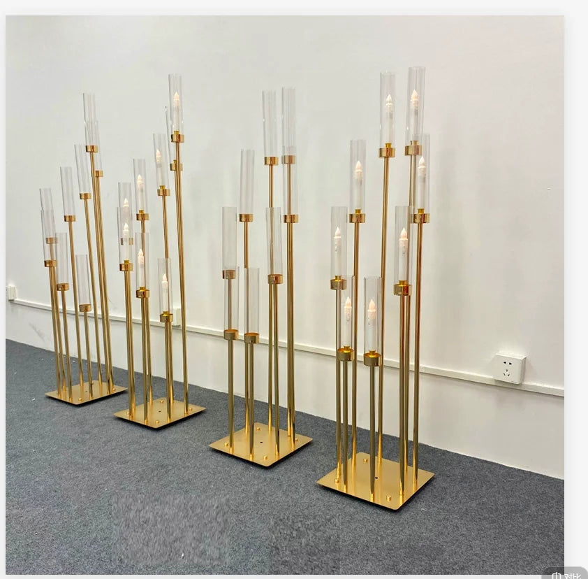 A set of eight gold metal candelabra with glass candles displayed on a gray carpet.