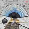 An elegant vintage Chinese folding hand fan displayed with bamboo sticks and a dark ceramic object.