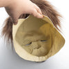 A hand is holding a vintage latex horror mask resembling Michael Myers, showing the facial features and texture.
