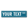 A rectangular teal metal street sign with the text YOUR TEXT and a smaller word TEXT.