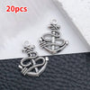 20 pieces of silver vintage ship anchor charms for jewelry making displayed on a dark surface.