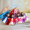A hand holds a colorful silicone keychain featuring Jesus figures and straps for religious purposes.