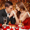 A woman and a man looking at each other while surrounded by red rose petals on a white table.