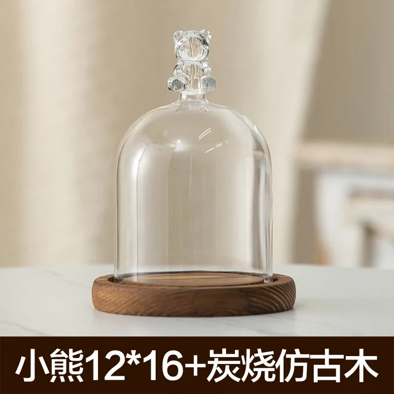 Glass aromatherapy candle holder with a clear dome and wooden base