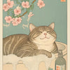 A watercolor illustration of a tabby cat resting on a light surface with pink blossoms and a glass bottle.