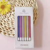 A set of 6 metallic birthday candles in various colors is displayed on a white card against a woven background.