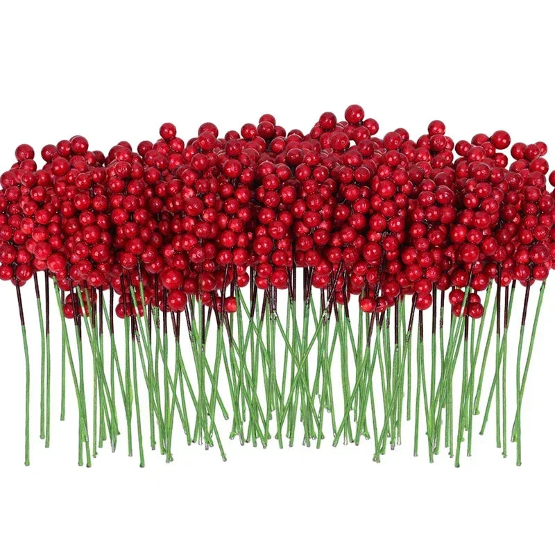 باقة أغصان من توت عيد الميلاد الاصطناعي الأحمر على سيقان خضراء.