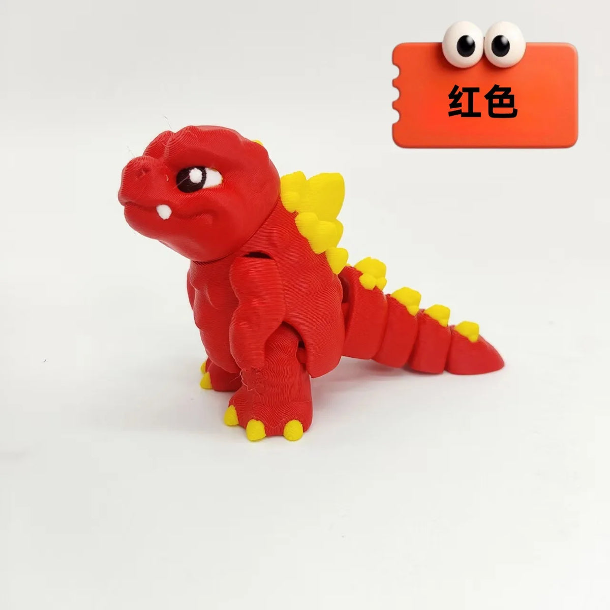 A red collectible 3D printed Godzilla sitting figure next to an orange tag labeled in Chinese characters.