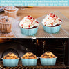 Blue ramekins filled with red cake batter are placed on a wire rack inside an oven.