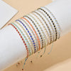 A stack of colorful glass bead bracelets on a wrist, featuring various shades of blue, gold, and red.
