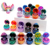 A collection of colorful 3D printed dragon eggs and mini dragon toys in various shades of pink, purple, green, and orange.