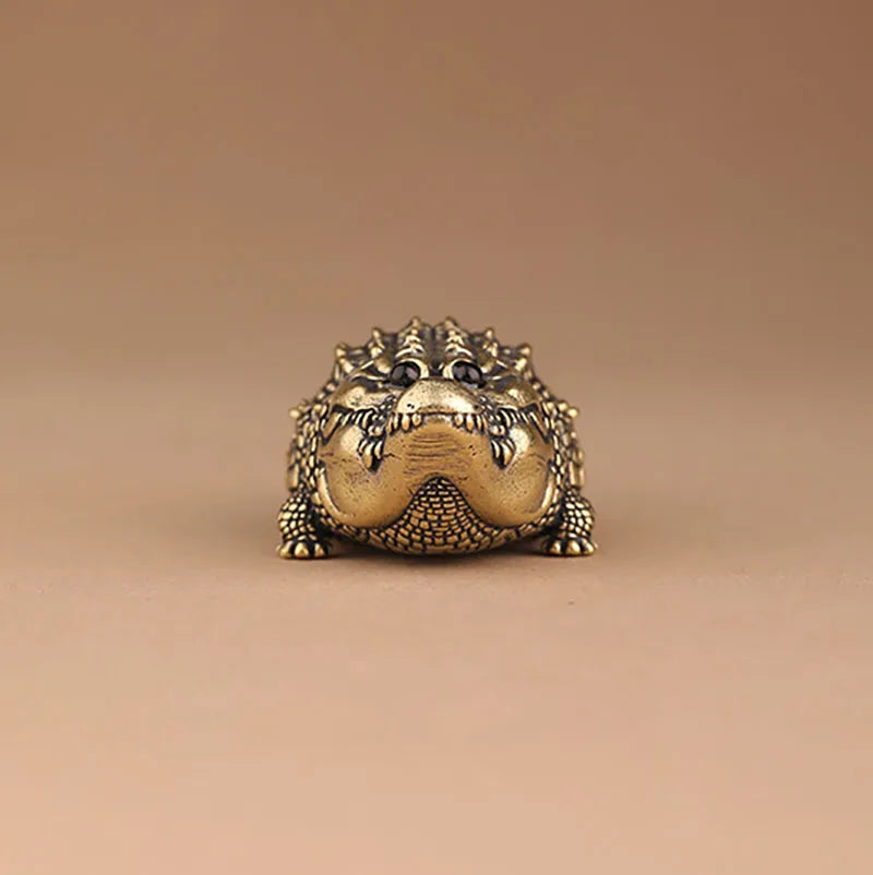 Antique brass crocodile figurine with detailed texture and expression, used as vintage desk decor.