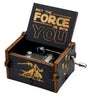 صندوق موسيقى خشبي ذو غطاء مفتوح يحمل عبارة "May The Force Be With You" ومقبض معدني صغير.
