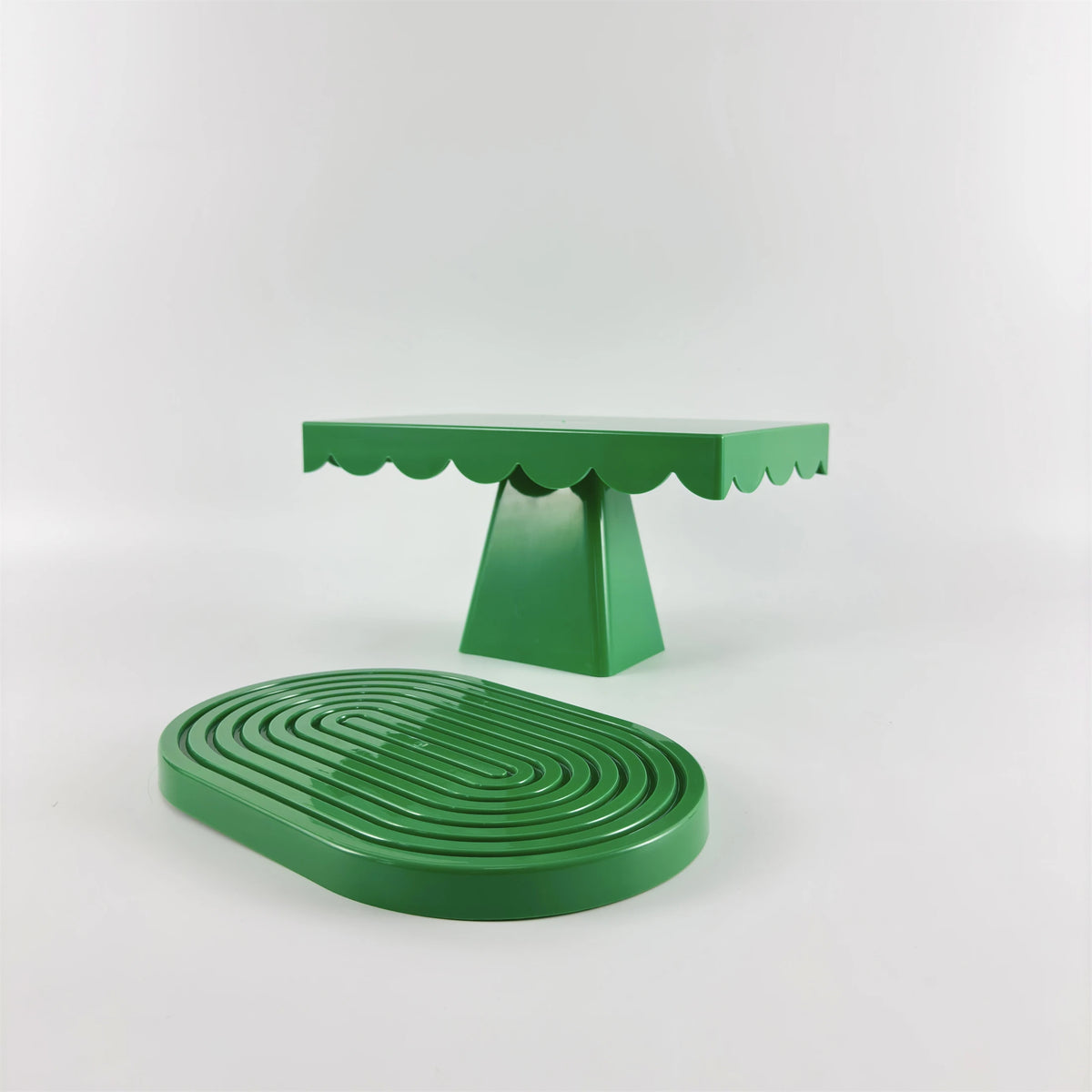 A green cupcake stand with a scalloped top and a round green serving tray.
