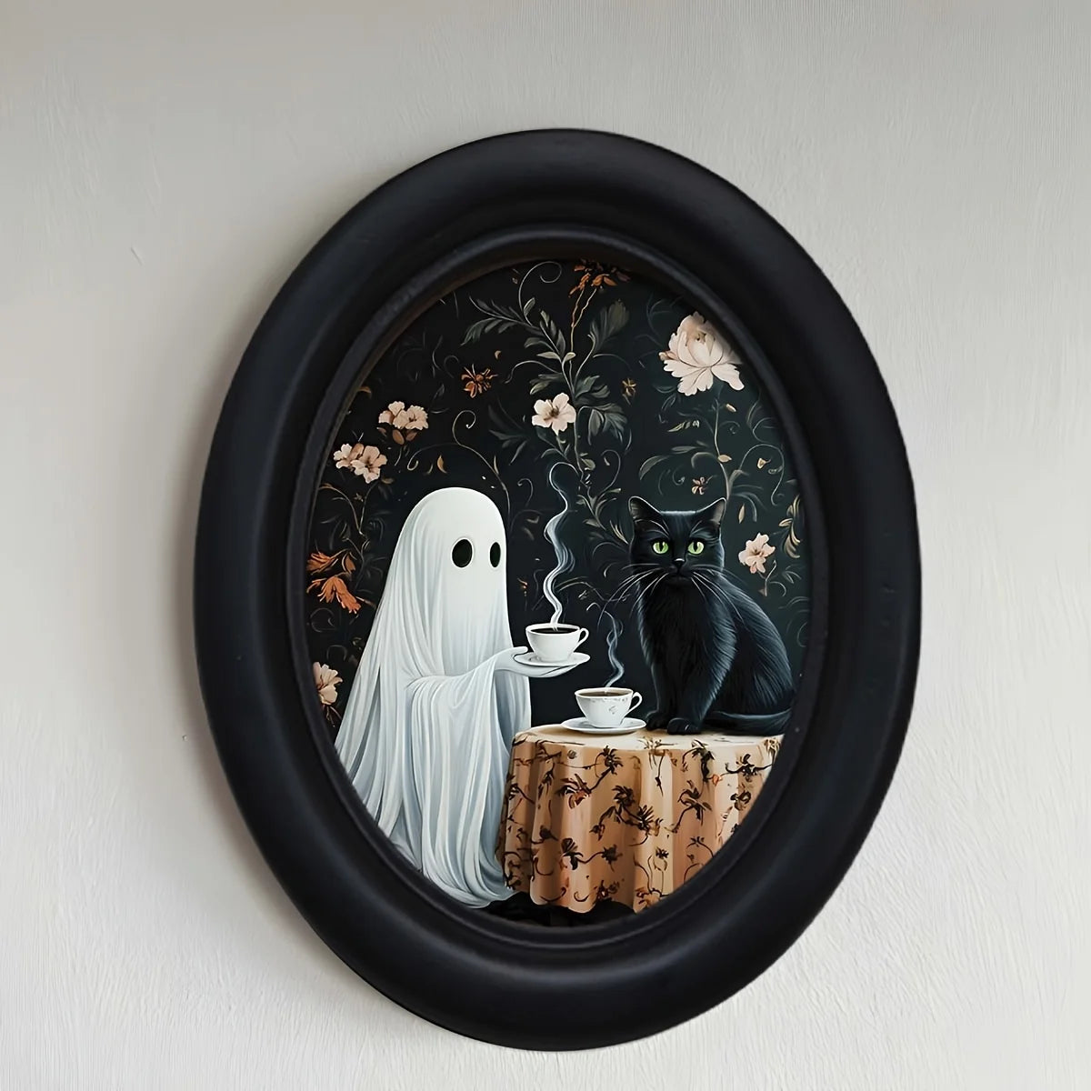 Oval framed wall art depicting a ghost figure and a black cat in a dark floral pattern.