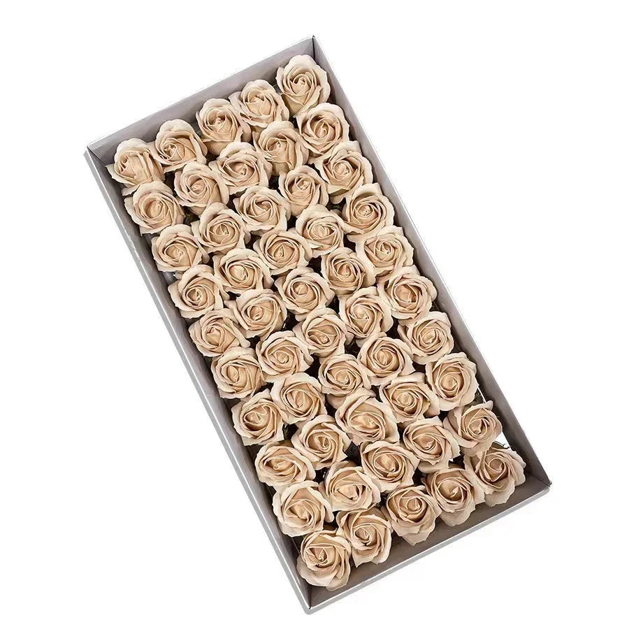 A rectangular box filled with numerous artificial rose heads in a beige or cream color for wedding and party decor.