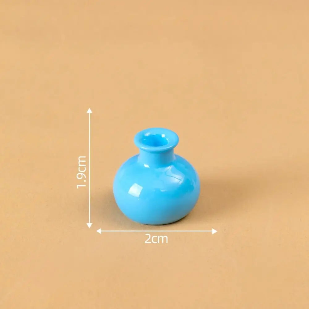 A small, bright blue resin vase with a round opening is shown against a beige background.