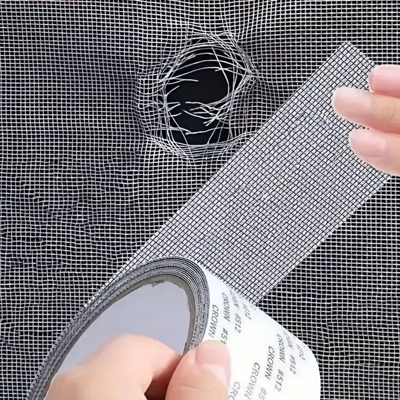 A hand is applying a self-adhesive window screen repair patch to a mesh screen, demonstrating a quick fix for holes or tears.