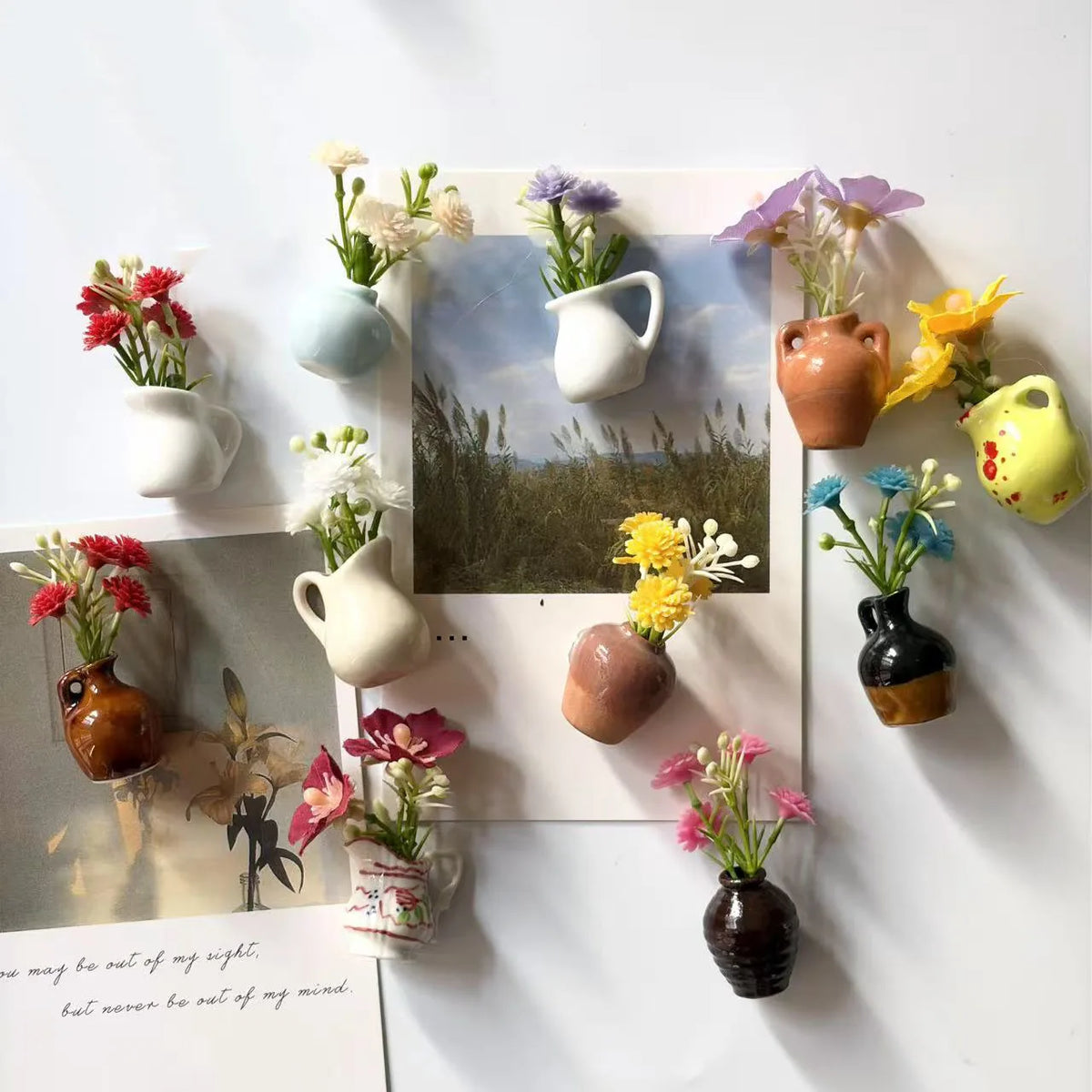 A collection of mini ceramic vases with artificial flowers displayed on a white background.
