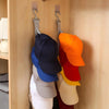 A rack displaying various colored hats hanging on a wooden closet rod.