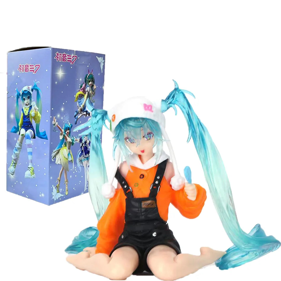 A PVC collectible figurine of Hatsune Miku in an orange outfit with black overalls and light blue hair, sitting on a purple b