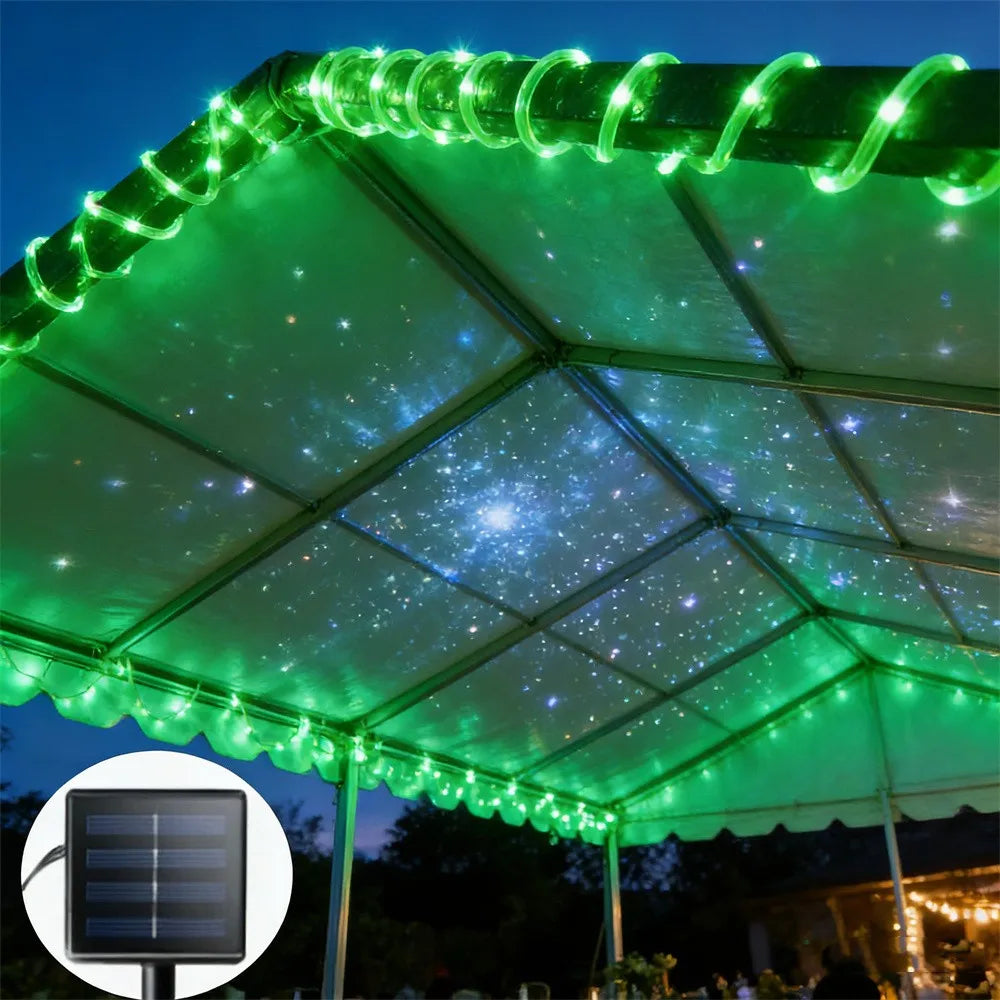 A green solar-powered LED rope light illuminates the underside of a tent or canopy structure.