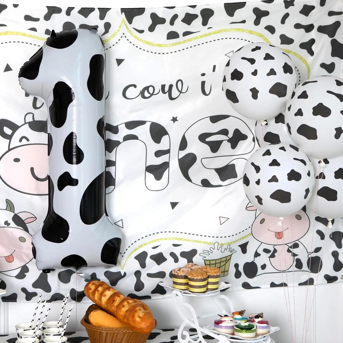A large silver foil balloon shaped like the number one in a cow print pattern is displayed against a white background.