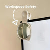 A beige convex mirror mounted on a wall, used for workspace safety.