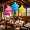 Lámpara de botella de flores vintage hecha a mano colgada en un interior rústico de madera con luz natural.