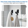 A set of black towel hooks hanging on a glass shower door, used for hanging towels and robes.