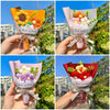 A hand holds a bouquet of handmade crochet flowers in pink and orange paper with a ribbon, labeled Best wishes.