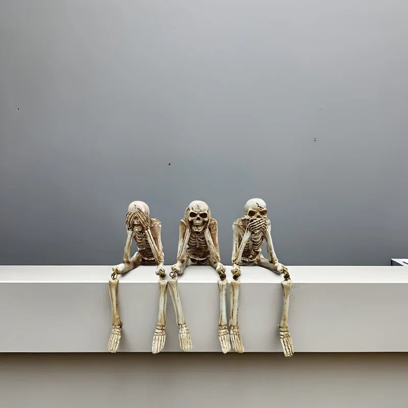 A set of realistic Halloween skeleton resin statues arranged in a seated position against a plain gray background.