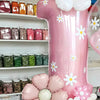 A large pink balloon shaped like a daisy is displayed next to various jars and floral balloons.