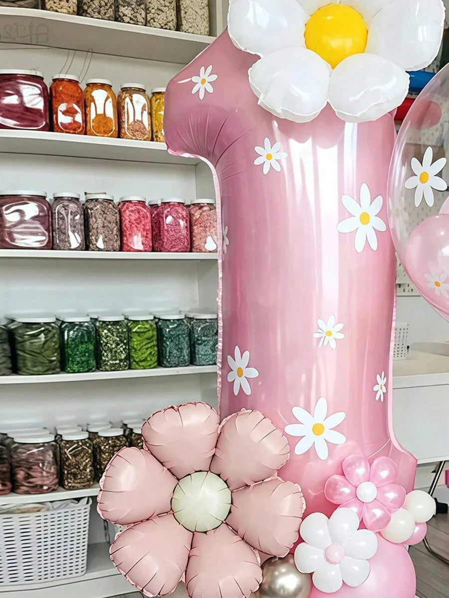 A large pink balloon shaped like a daisy is displayed next to various jars and floral balloons.
