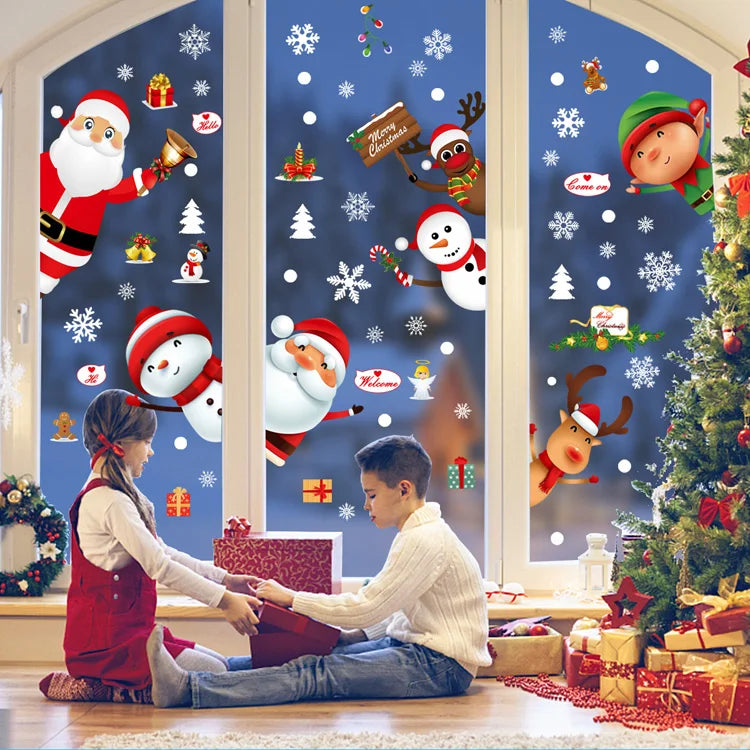 A boy and a girl are decorating a window with festive Christmas stickers featuring a snowman, deer, and Santa Claus.